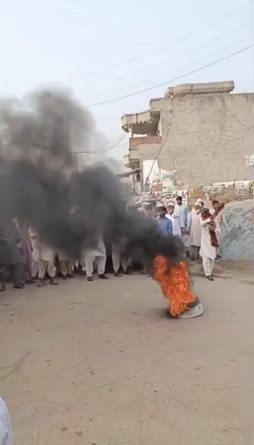 A tyre set alight on the village road in Gharial Kalan during the protest